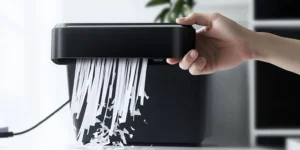 Papel triturado en tiras generado por una trituradora portátil, mostrando tiras largas y delgadas esparcidas sobre una superficie, típico del corte en tiras.